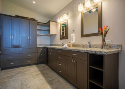 The large ensuite bathroom of the Catarata Suite, with brown cabinetry lining the walls and double sinks.