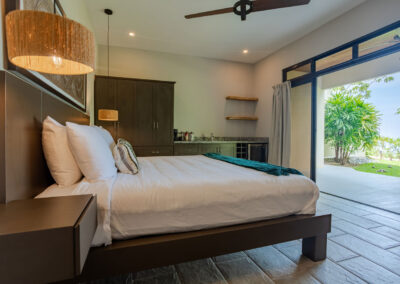 A king bed, clothing storage, and a wet bar in the Oceano Suite with doors leading to the private covered patio.