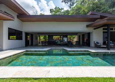 A front exterior view of Villa Ballena featuring an outdoor covered living space and a large pool.